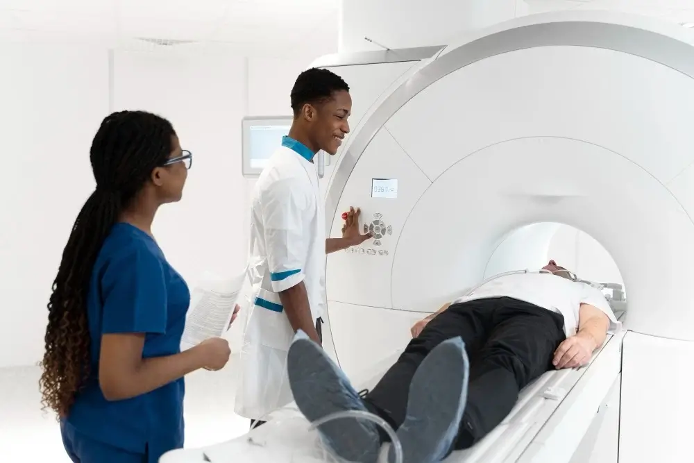 Image featuring two medical professionals providing treatment to a patient lying on a bed in a healthcare setting.